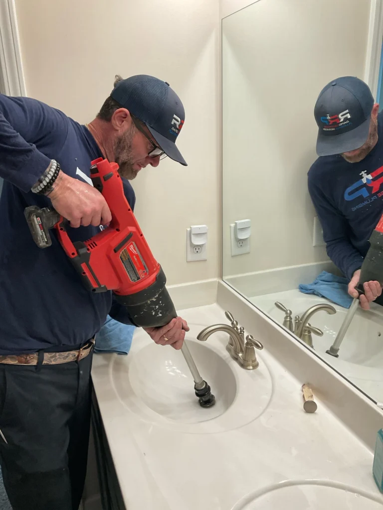 Plumber snaking bathroom sink drain by Rapid Response Plumbing in Lawrenceville GA